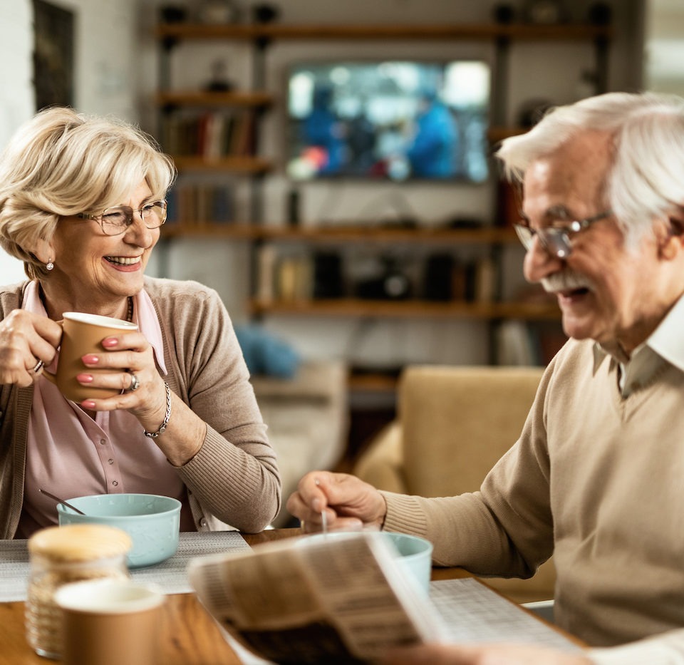 Happy senior couple enjoying in breakfast at home. Focus is on happy senior woman drinking coffee.