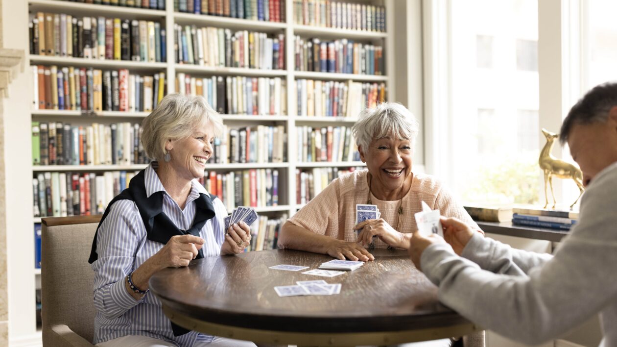 Smiling seniors playing cards