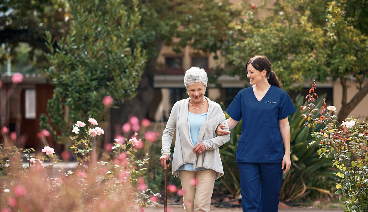 Shot of a caregiver and her patient out for a walk in the garden.