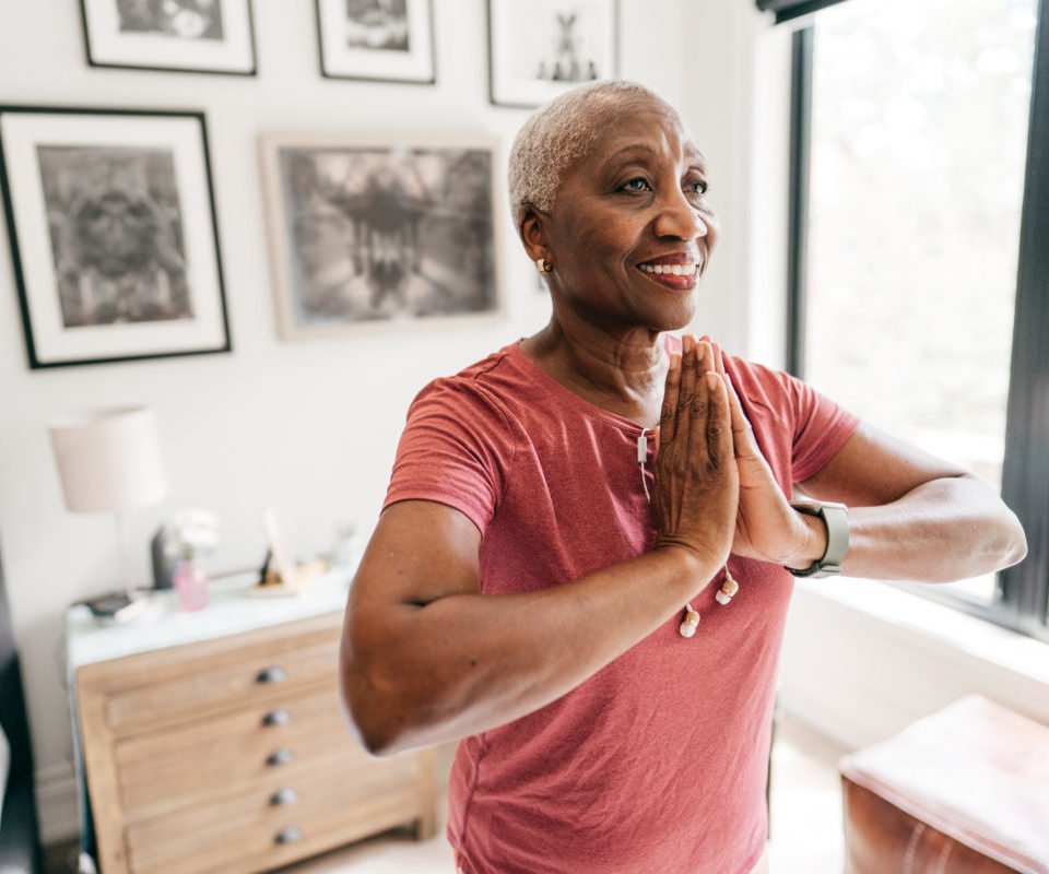 Senior woman exercising at home in sportswear.