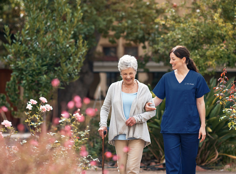Shot of a caregiver and her patient out for a walk in the garden
