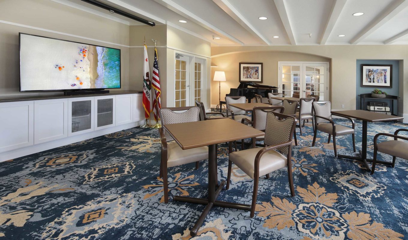 Roseville activity room with seating areas, piano and TV screen