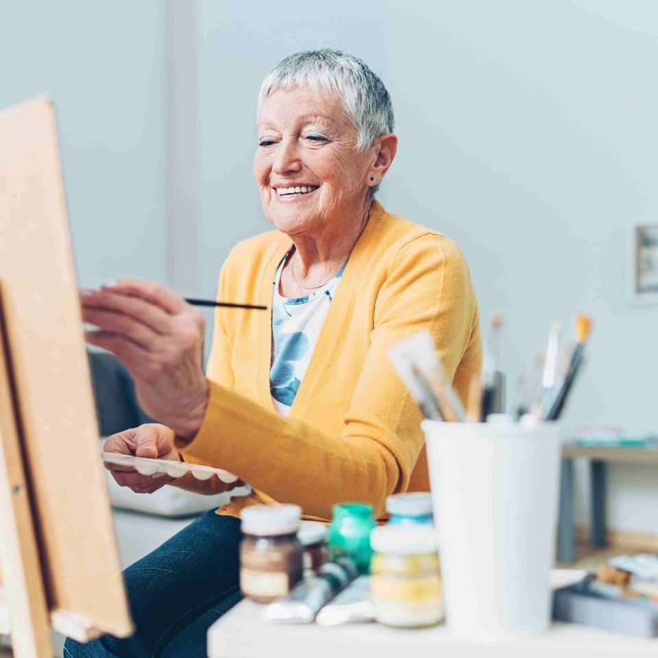 Senior artist woman drawing at home