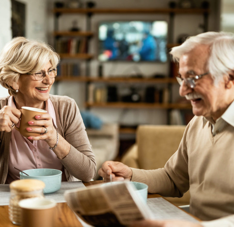 A man and woman enjoying cups of coffee and cereal.