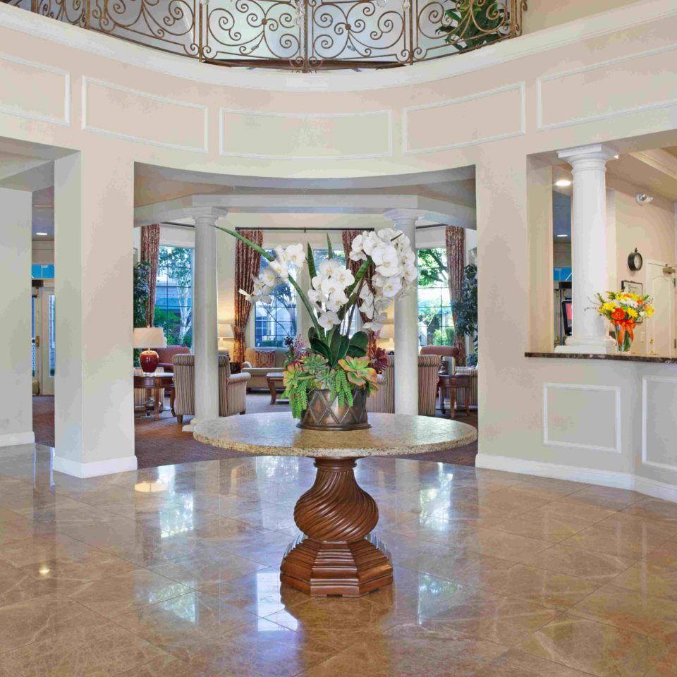 Photo of main lobby, with a marble and wood table with flowers on top.