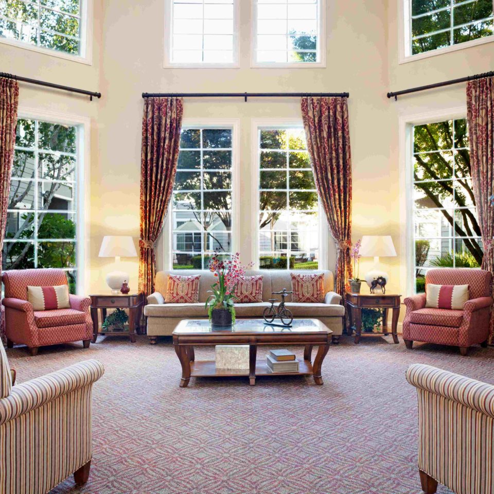 Photo of San Ramon sitting room, with large windows, couches and chairs.