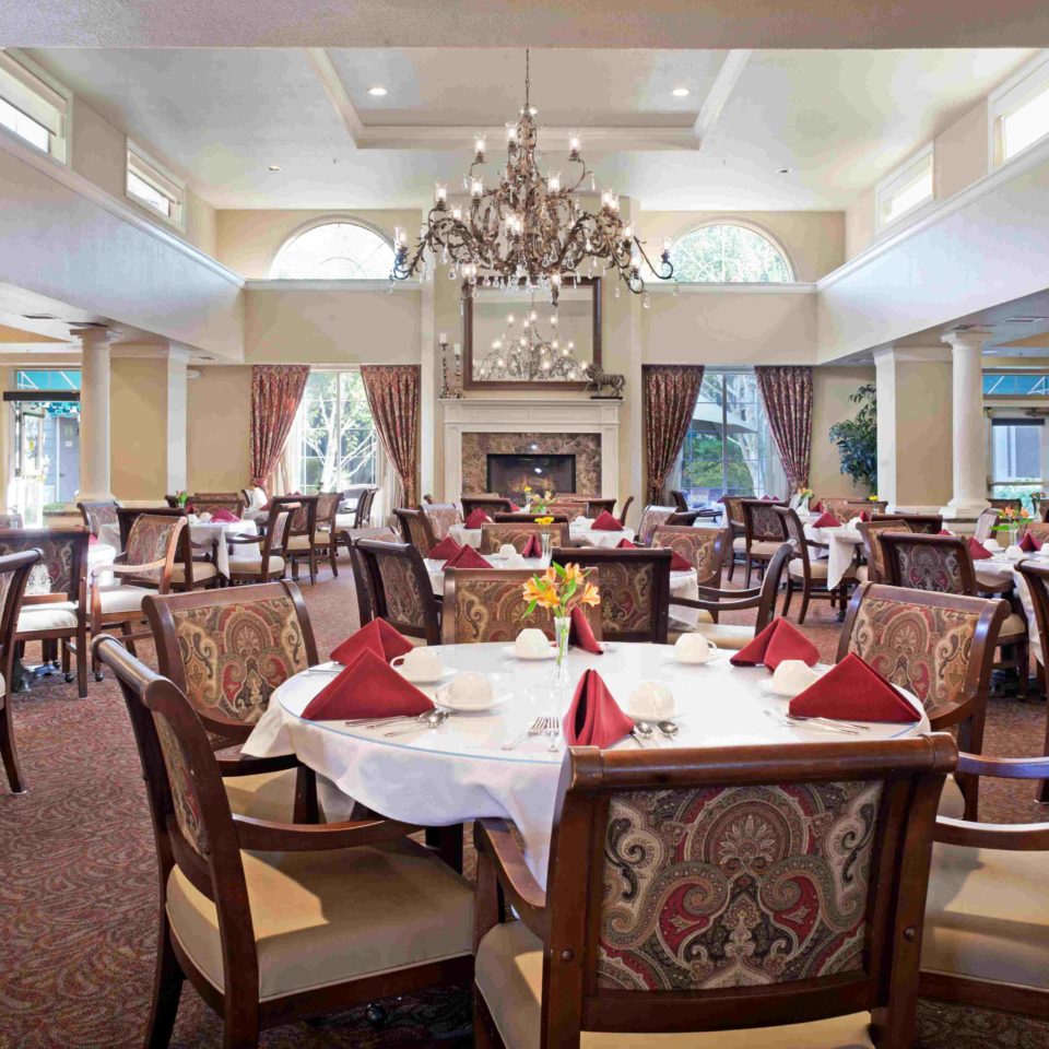 Photo of Ivy Park at San Ramon dining room, with rows of decorated tables and a chandelier.