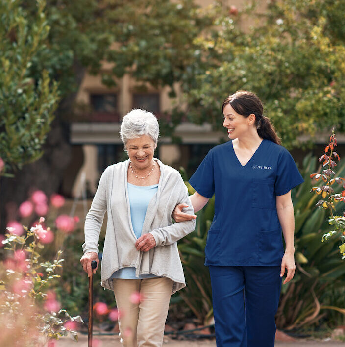 Shot of a caregiver and her patient out for a walk in the garden.