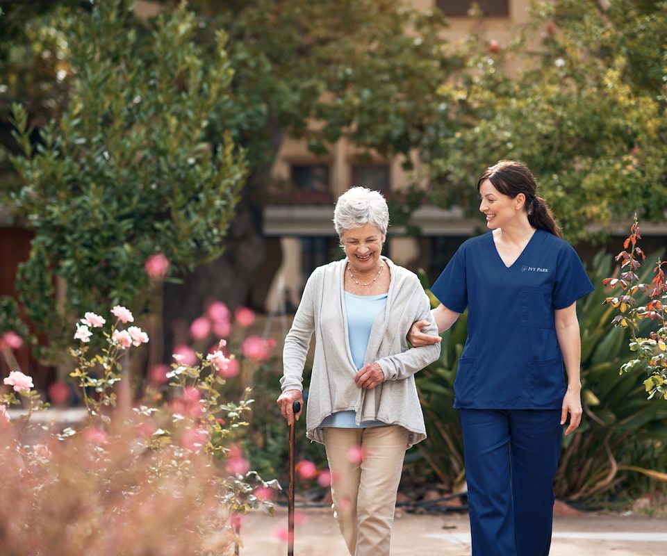 Shot of a caregiver and her patient out for a walk in the garden.