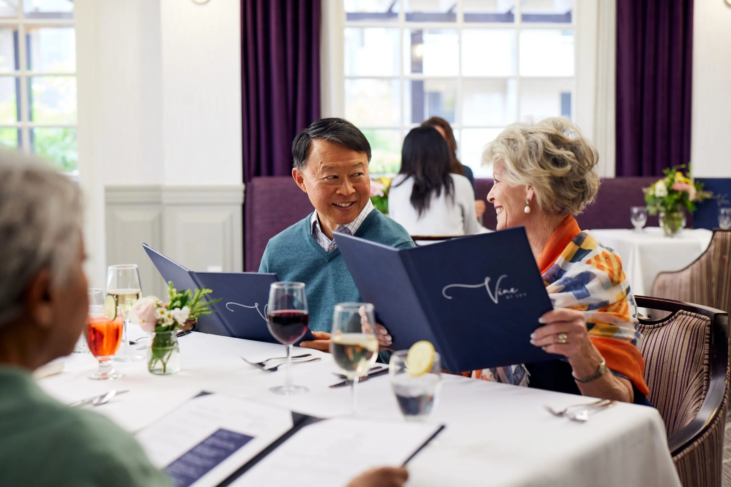 Senior couple enjoying dinner at a fancy table.