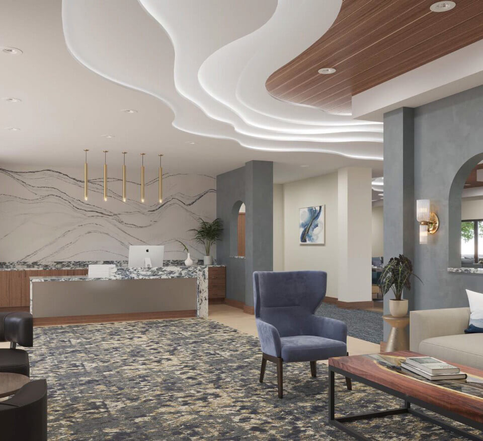 A modern interior of the lobby with a layered wavy ceiling and a large wavy marble accented wall behind the front desk. Chairs and coffee tables in the open space.