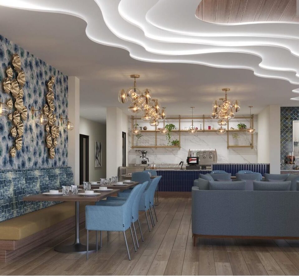 View of the bistro with bench seating across from single arm chairs. A wavy layered ceiling pattern flows through the space. Blue furniture with gold accents fill the area.