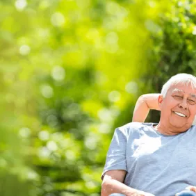 senior-man-smiling-in-park-with-caregiver