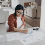 woman-working-on-charts-in-living-room