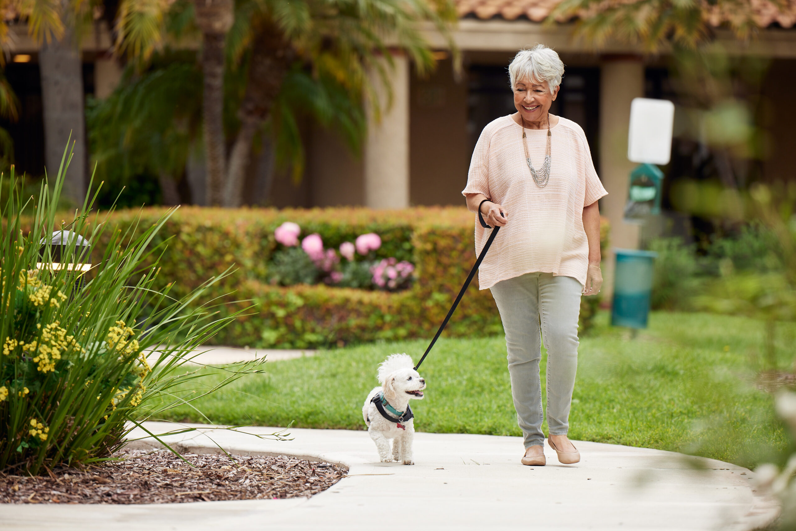 senior-woman-taking-out-dog-in-a-garden