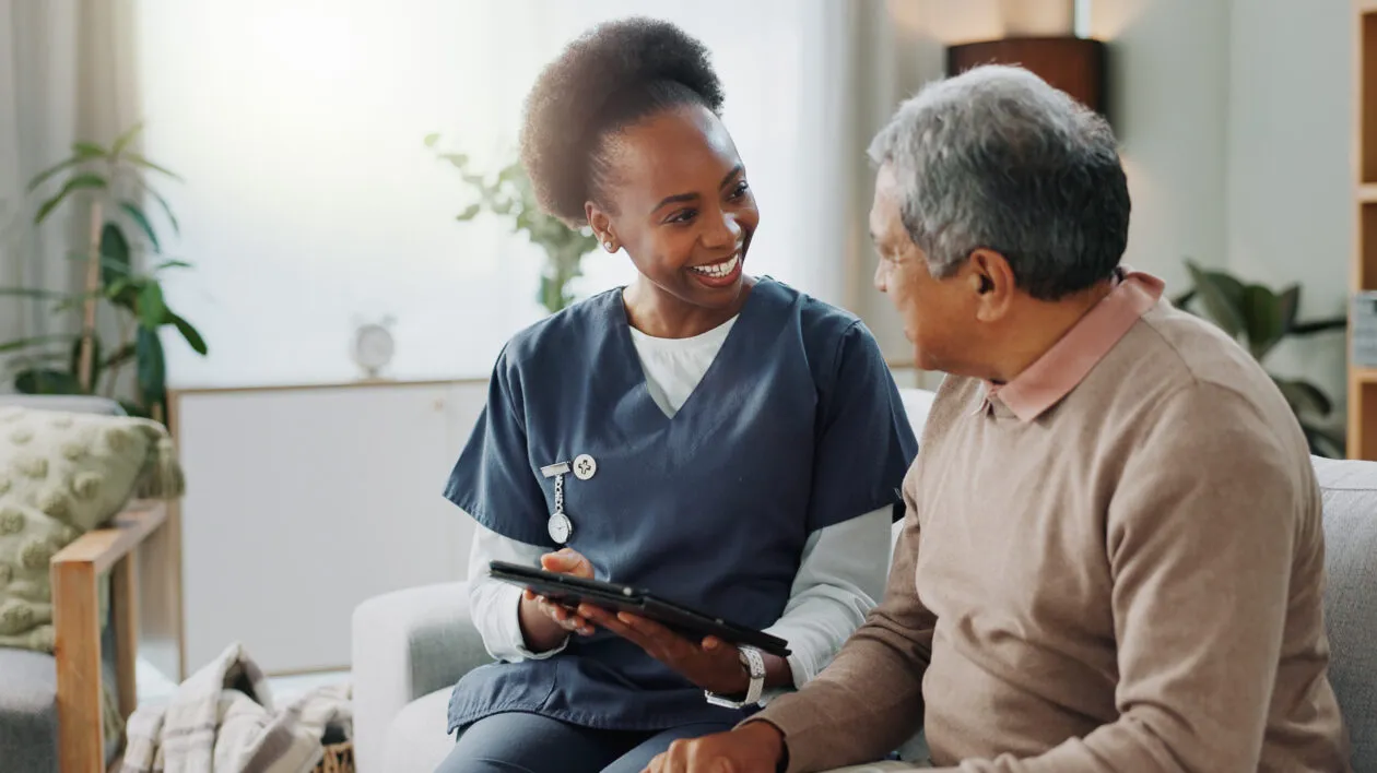 Healthcare nurse with senior, online help on sofa. Young caregiver, elderly person.