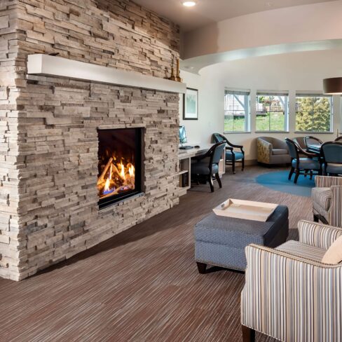 Cozy fireplace inside a luxury senior living community lounge, offering a warm and inviting atmosphere for residents.